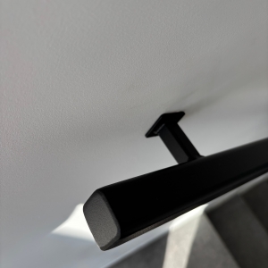 Trapleuning tegen de muur gelakt detail